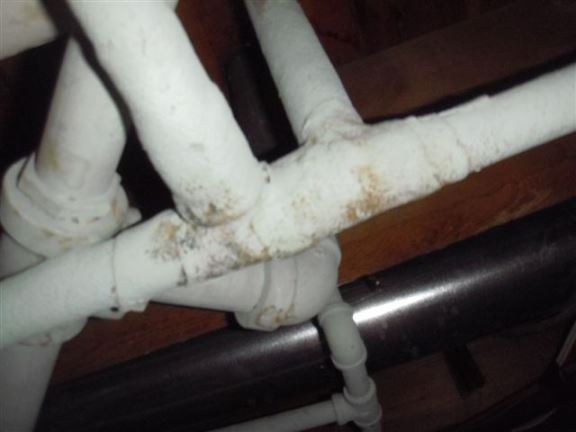 Asbestos-wrapped heating pipes in the crawl space.