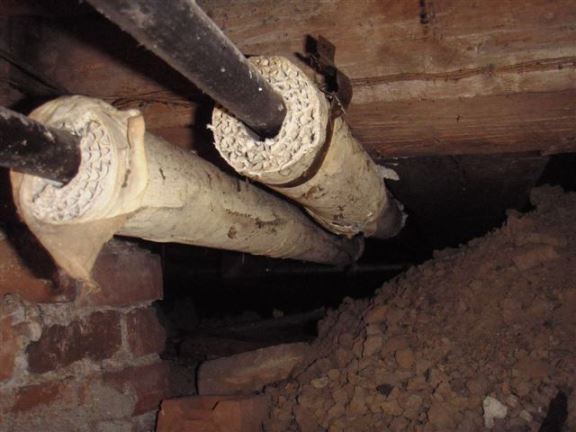 The asbestos on these heating pipes, if disturbed, could become airborne and cause serious respiratory problems. 