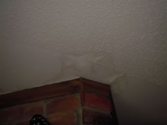 Here you can see a water-damaged ceiling near a chimney – most likely due to a flashing issue.