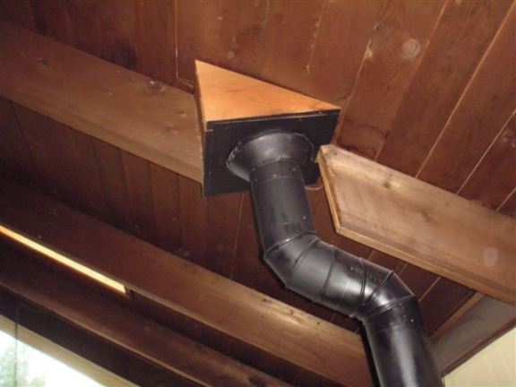 Whoever installed this wood stove pipe decided it was a good idea to cut through the roof rafter rather than moving the pipe. This will cause the roof to sag, plus the fact that its a fire hazard.