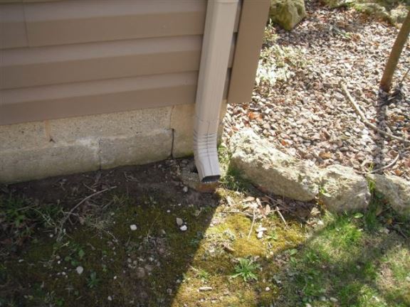 This downspout dumps water too close to house and should be extended to avoid moisture problems.