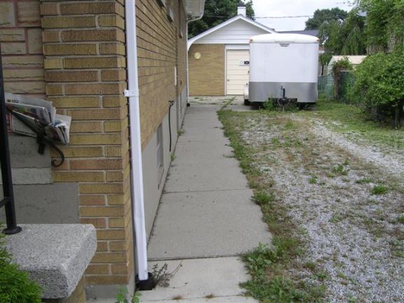 This sidewalk slopes towards the house, causing basement seepage issues.
